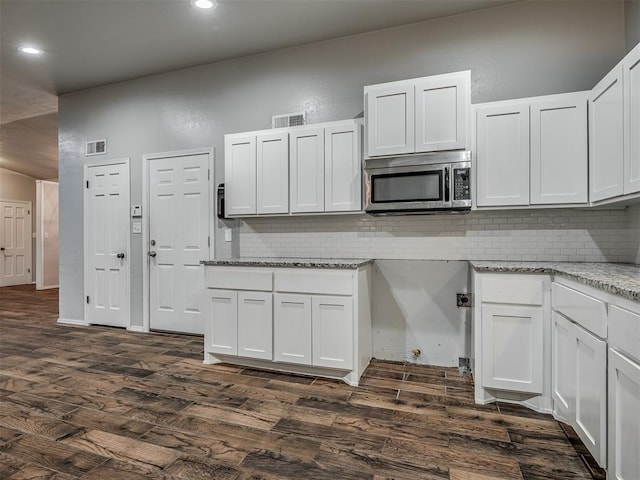 kitchen featuring white cabinets, dark hardwood / wood-style flooring, and light stone countertops