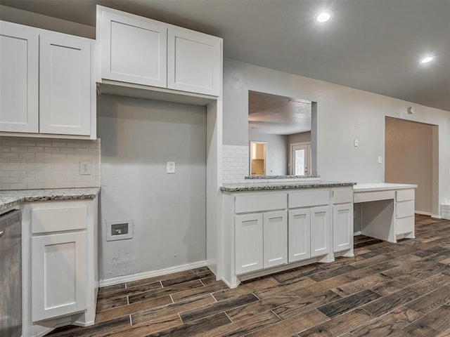 kitchen with light stone countertops, white cabinetry, stainless steel dishwasher, and dark hardwood / wood-style floors