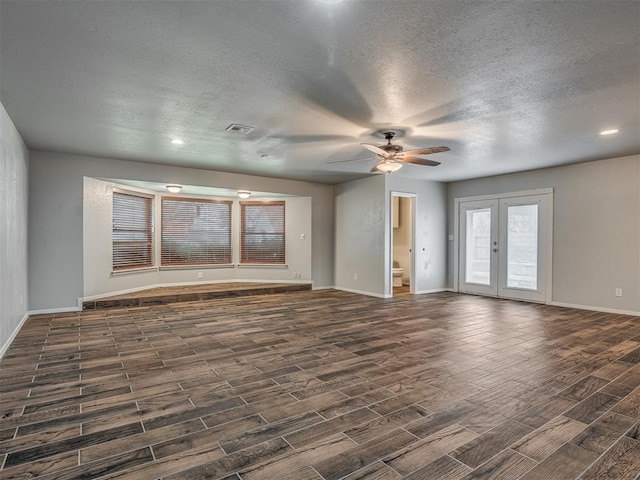 unfurnished living room with a textured ceiling, ceiling fan, dark hardwood / wood-style flooring, and french doors