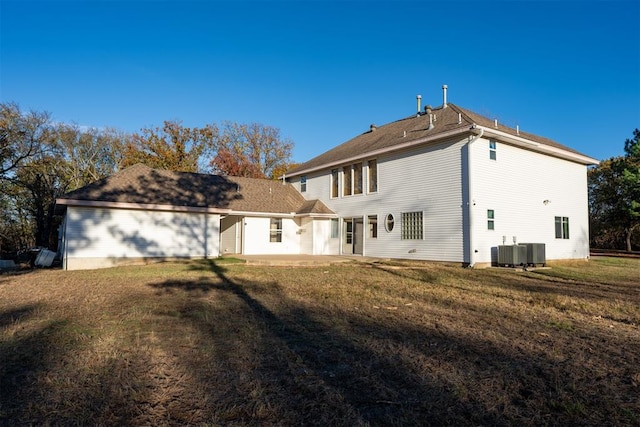 rear view of house featuring a lawn, central air condition unit, and a patio