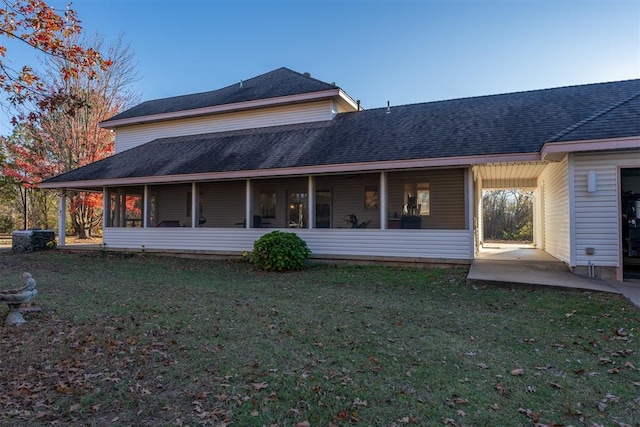 back of house featuring a patio area and a lawn