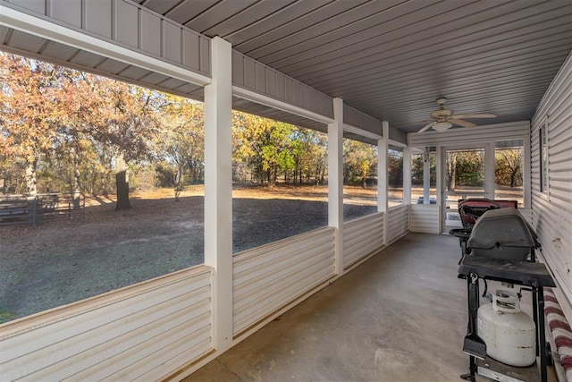 unfurnished sunroom featuring ceiling fan