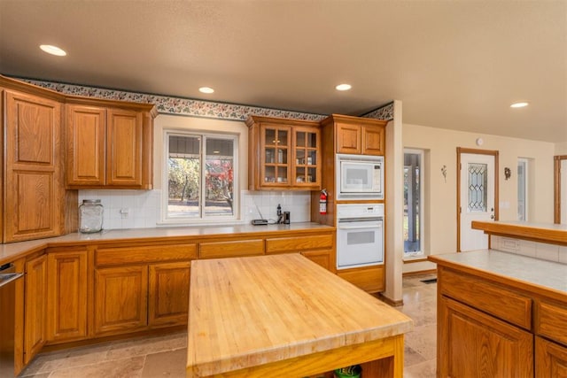 kitchen with wood counters, a kitchen island, white appliances, and backsplash