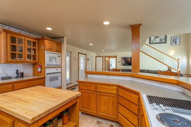 kitchen featuring a center island, wood counters, tasteful backsplash, kitchen peninsula, and white appliances