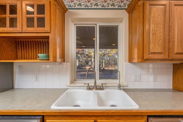 kitchen featuring dishwasher, tasteful backsplash, and sink