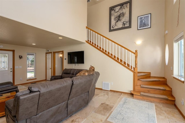 living room with plenty of natural light and a towering ceiling