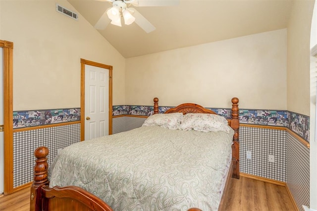 bedroom with ceiling fan, vaulted ceiling, and light wood-type flooring