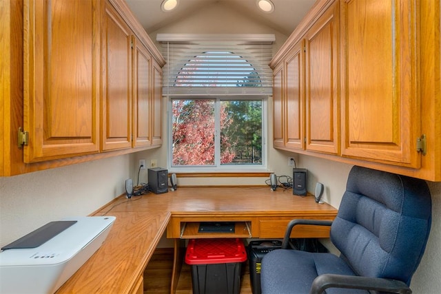 office space featuring hardwood / wood-style flooring, built in desk, and lofted ceiling