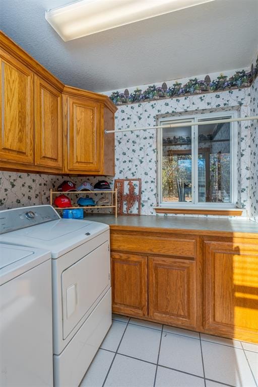 laundry area featuring cabinets, separate washer and dryer, and light tile patterned floors