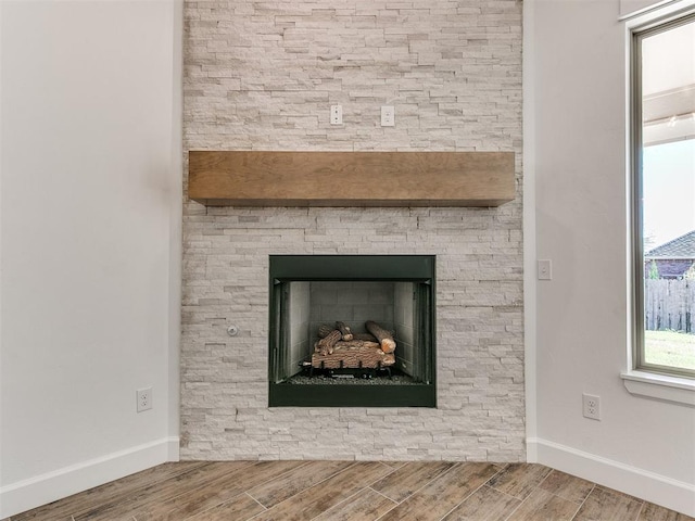 room details featuring hardwood / wood-style flooring and a stone fireplace