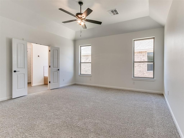 carpeted empty room featuring ceiling fan, a wealth of natural light, and vaulted ceiling