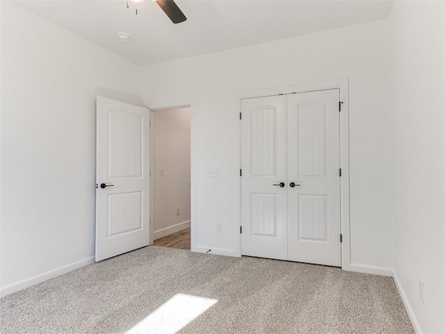 unfurnished bedroom featuring ceiling fan, light carpet, and a closet