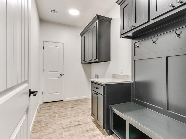 washroom featuring washer hookup, cabinets, and light wood-type flooring