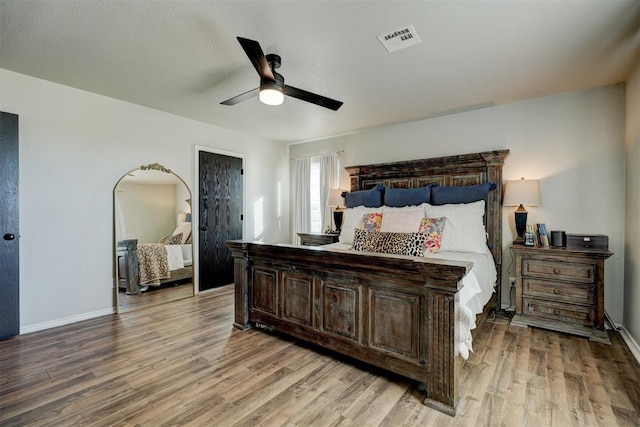 bedroom with light hardwood / wood-style floors and ceiling fan