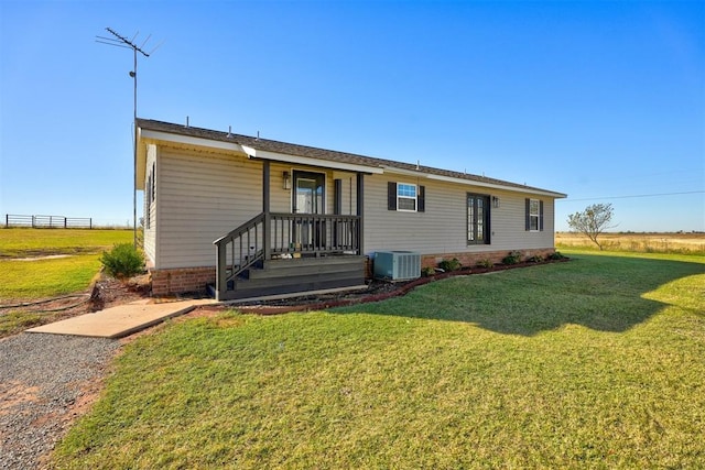 back of house featuring a yard and central AC