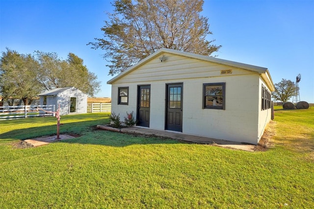 back of house featuring an outbuilding and a lawn