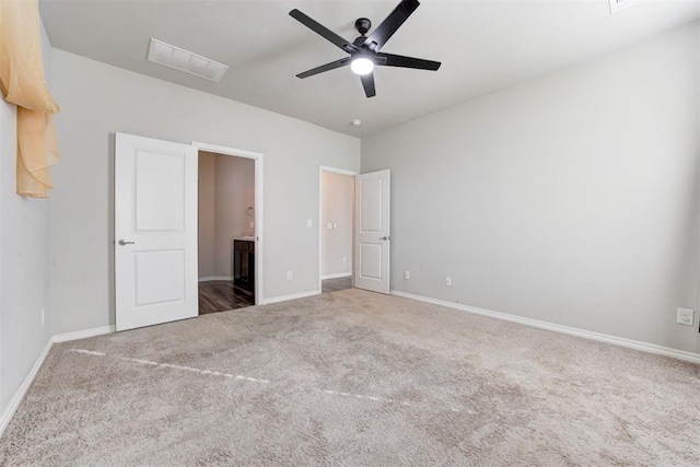 unfurnished bedroom featuring ceiling fan, carpet floors, and ensuite bathroom