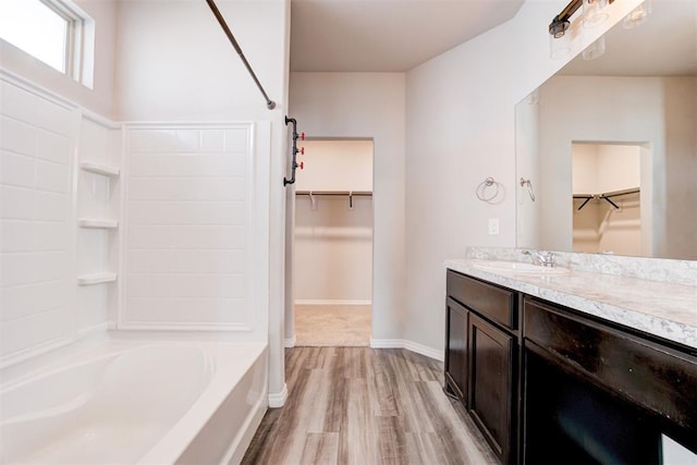 bathroom with hardwood / wood-style flooring, vanity, and bathing tub / shower combination