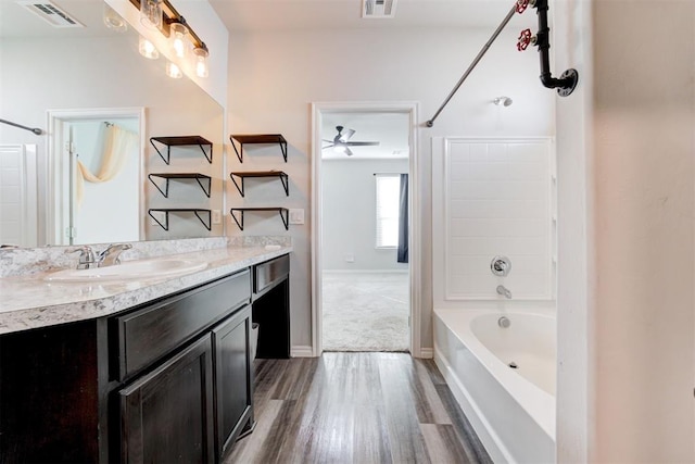 bathroom with hardwood / wood-style flooring, shower / bath combination, vanity, and ceiling fan