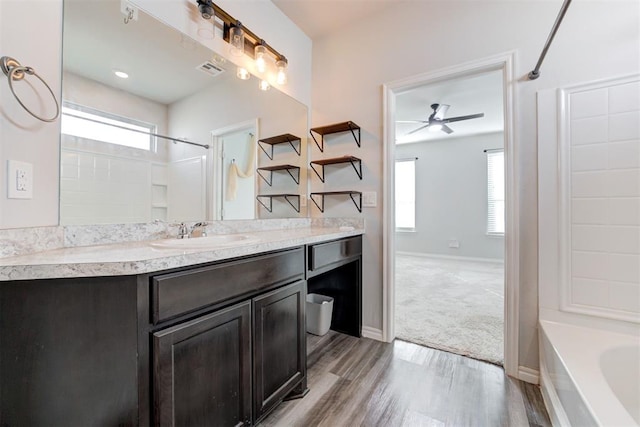 bathroom featuring ceiling fan, vanity, shower / washtub combination, and hardwood / wood-style flooring