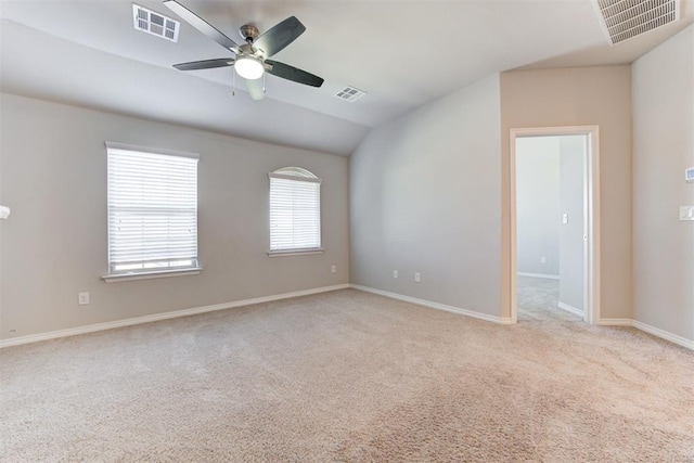 carpeted spare room featuring ceiling fan and vaulted ceiling