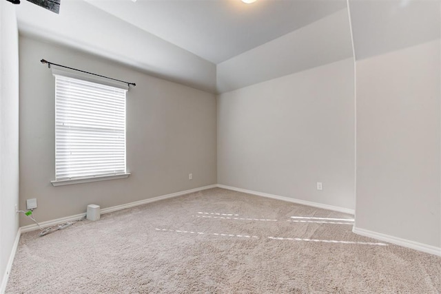 empty room featuring lofted ceiling and carpet floors