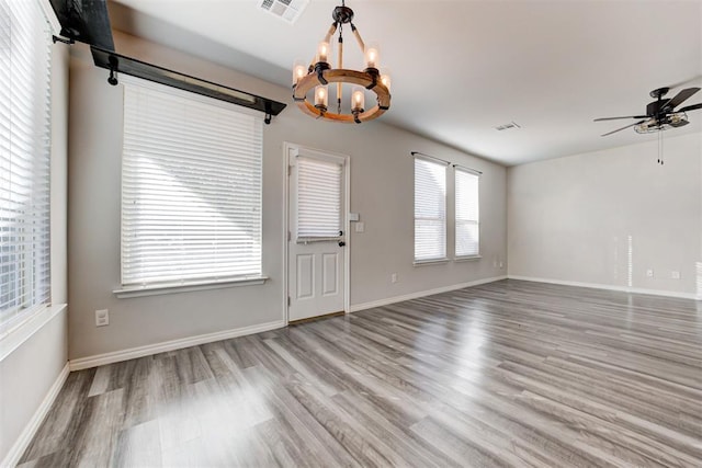 interior space with ceiling fan with notable chandelier and wood-type flooring