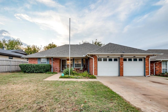 ranch-style house featuring a garage, a front lawn, and covered porch