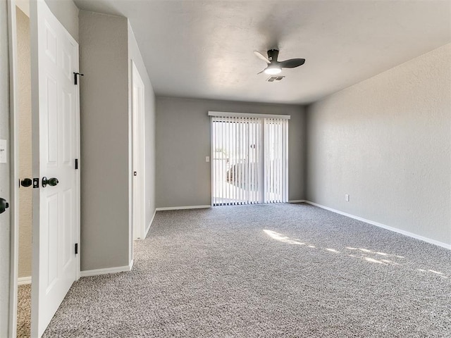 empty room featuring ceiling fan and carpet