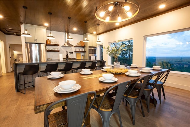 dining room featuring light hardwood / wood-style floors and wood ceiling