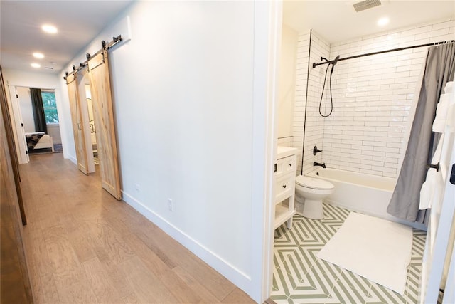 full bathroom featuring hardwood / wood-style flooring, vanity, toilet, and shower / bathtub combination with curtain