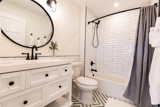 full bathroom featuring tile patterned flooring, shower / bath combo with shower curtain, vanity, and toilet