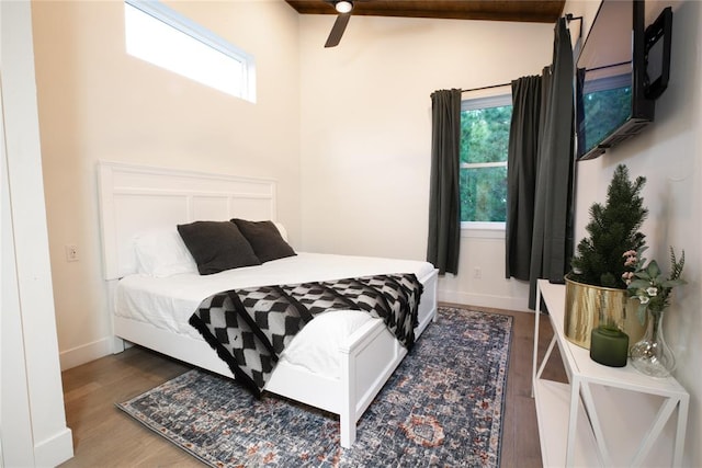 bedroom featuring hardwood / wood-style flooring, lofted ceiling with beams, and ceiling fan