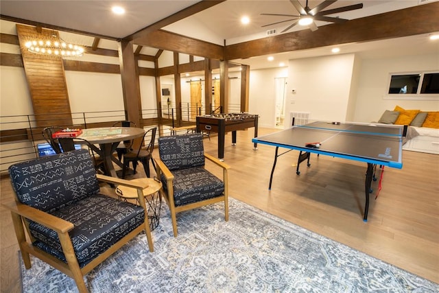 playroom with hardwood / wood-style floors, lofted ceiling with beams, and ceiling fan with notable chandelier