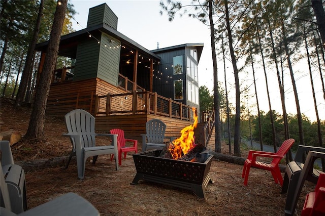 view of jungle gym featuring an outdoor fire pit and a wooden deck