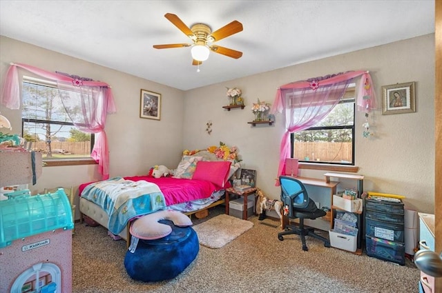 carpeted bedroom featuring ceiling fan and multiple windows