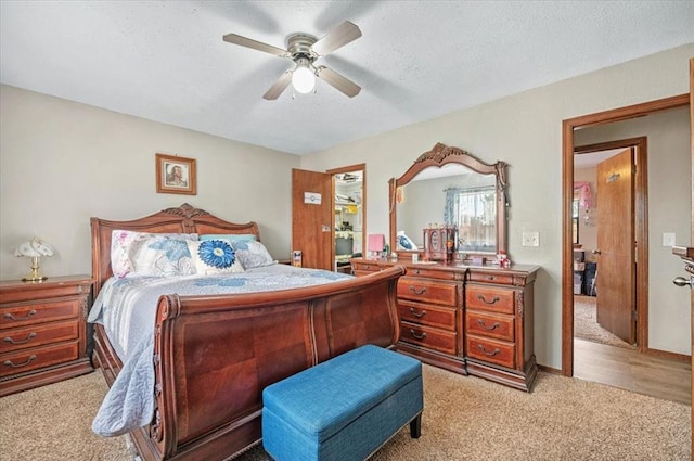 bedroom with light carpet, a textured ceiling, and ceiling fan