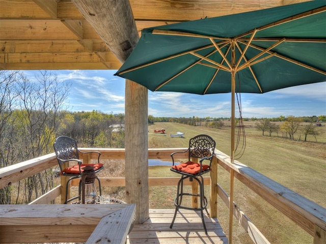 wooden deck with a yard and a rural view