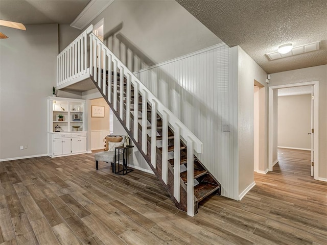 stairs with hardwood / wood-style floors and a textured ceiling