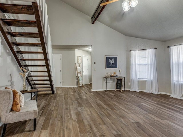 unfurnished living room featuring hardwood / wood-style floors, beamed ceiling, and high vaulted ceiling