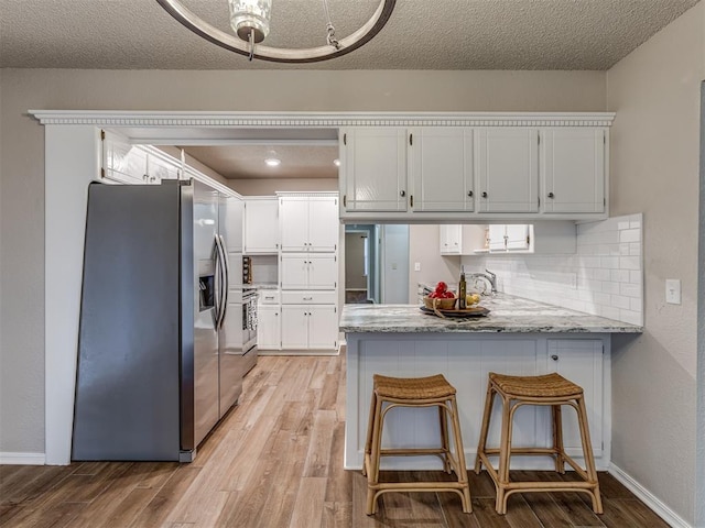 kitchen with white cabinets, stainless steel appliances, and kitchen peninsula