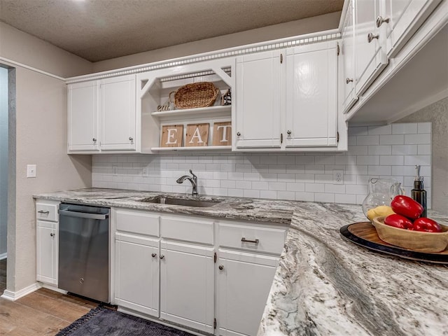 kitchen with dishwasher, sink, white cabinets, and light hardwood / wood-style floors