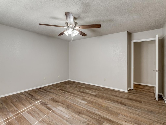 empty room with wood-type flooring, a textured ceiling, and ceiling fan