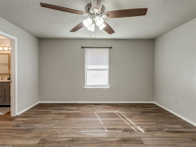 spare room featuring ceiling fan, a textured ceiling, and hardwood / wood-style flooring