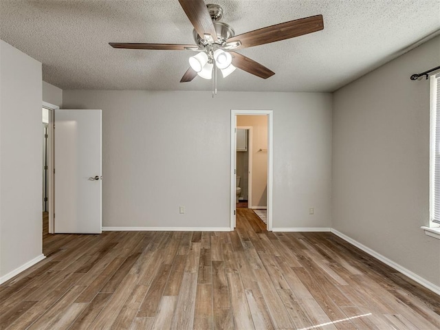 unfurnished room with ceiling fan, light hardwood / wood-style floors, and a textured ceiling