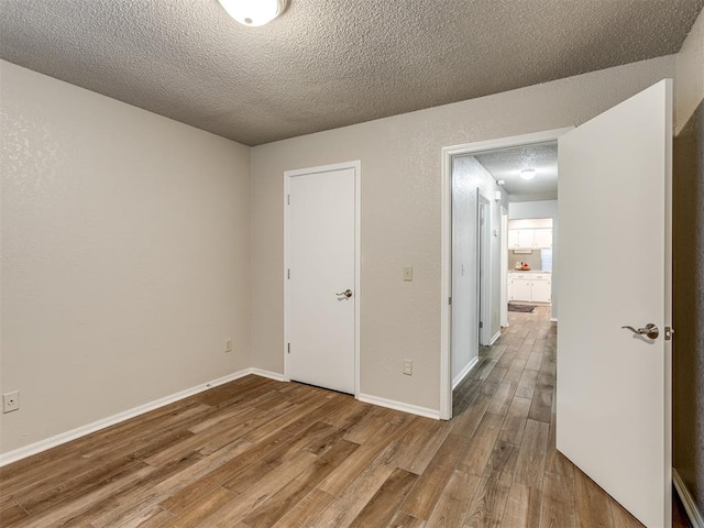 empty room featuring light hardwood / wood-style floors and a textured ceiling