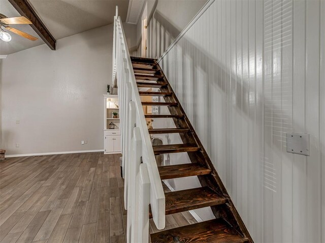 stairway featuring vaulted ceiling with beams, hardwood / wood-style flooring, and ceiling fan