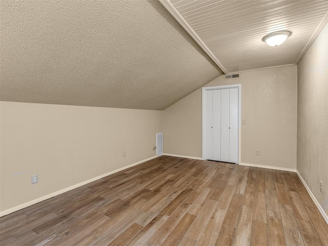 bonus room with hardwood / wood-style flooring and lofted ceiling