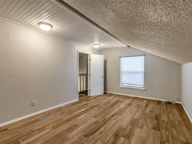 bonus room with wood-type flooring and vaulted ceiling