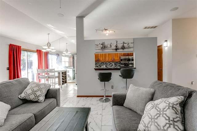 living room with lofted ceiling and a notable chandelier